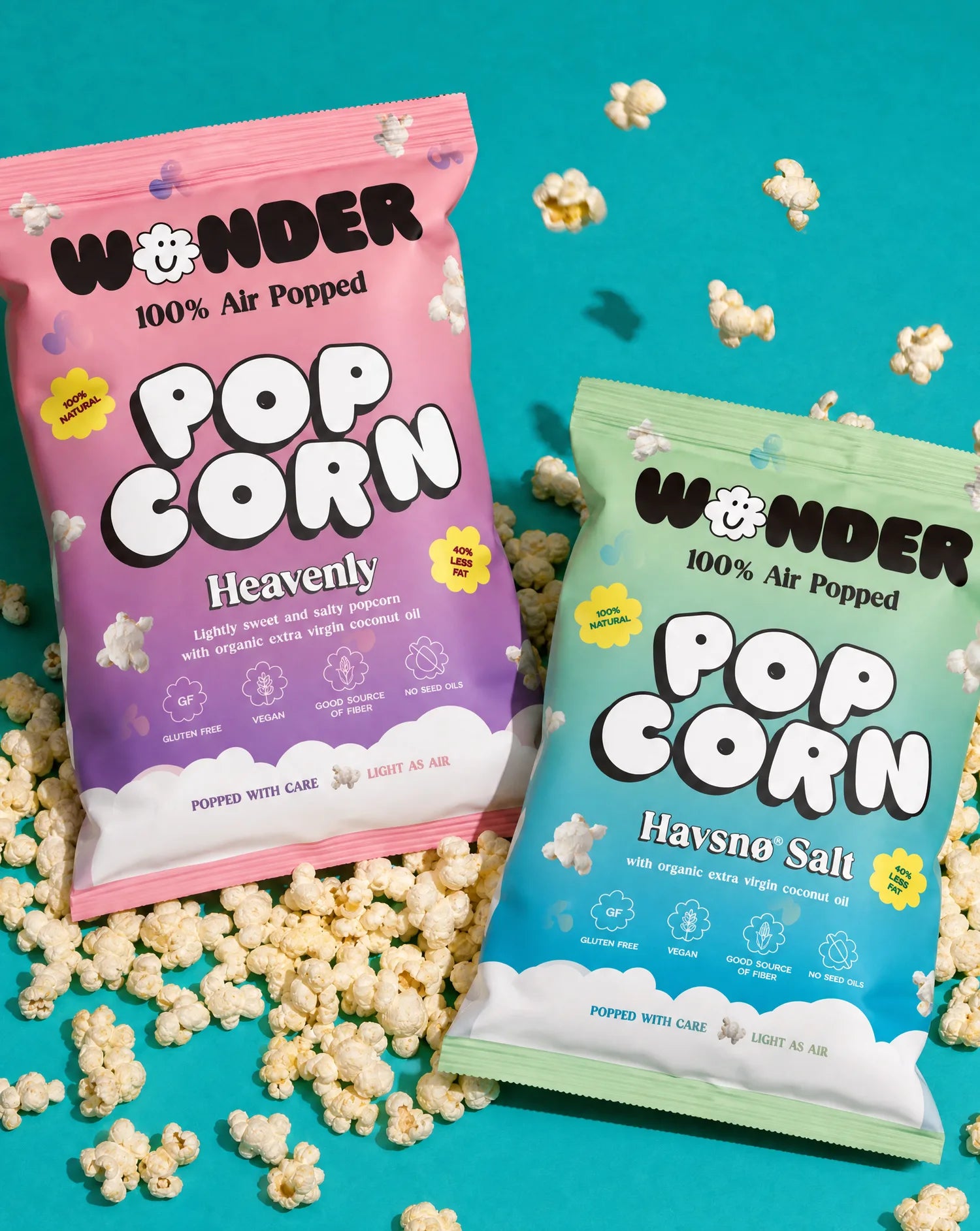 Both Wonder popcorn bags on a teal surface covered in popcorn